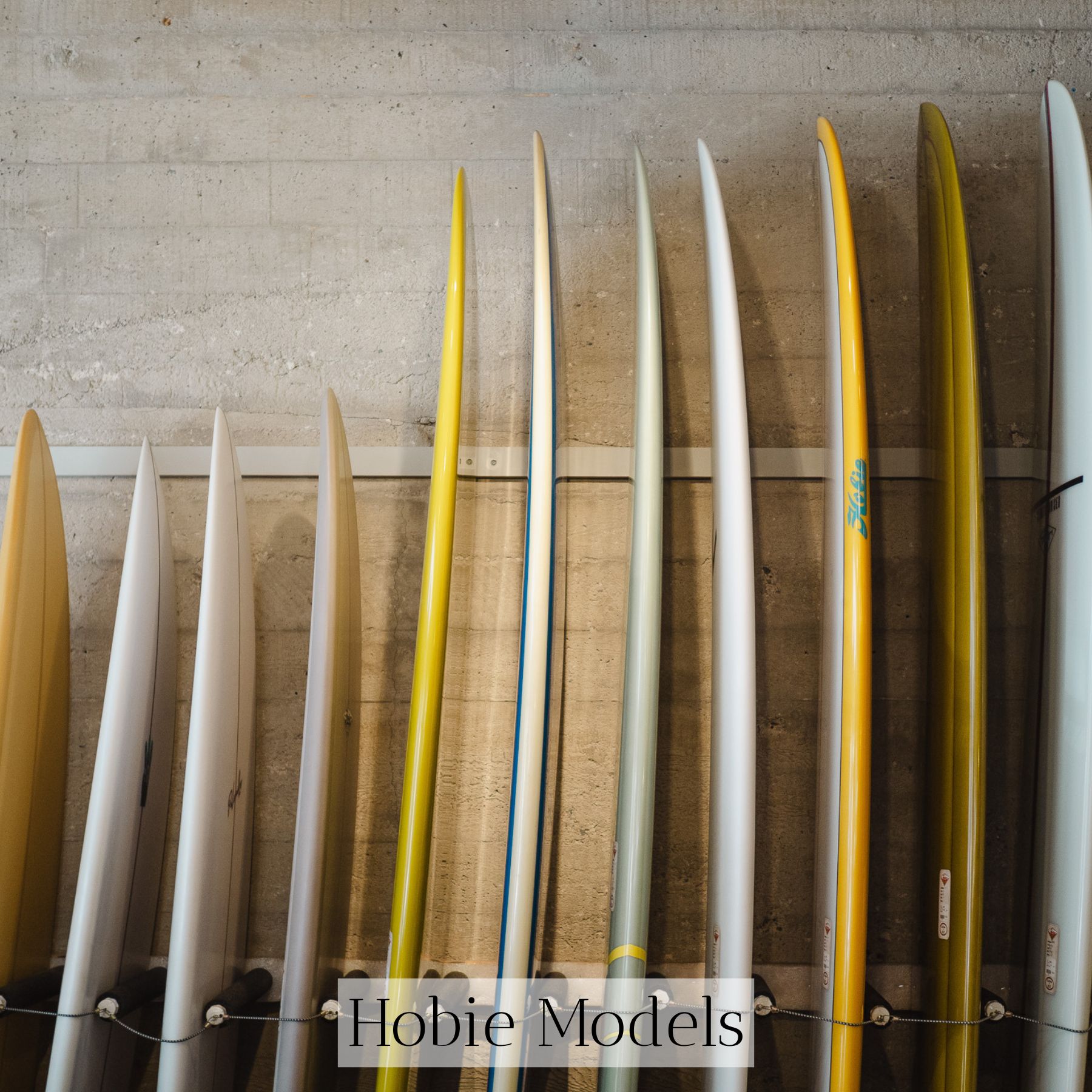 hobie alter standing in the window of his original surf shop